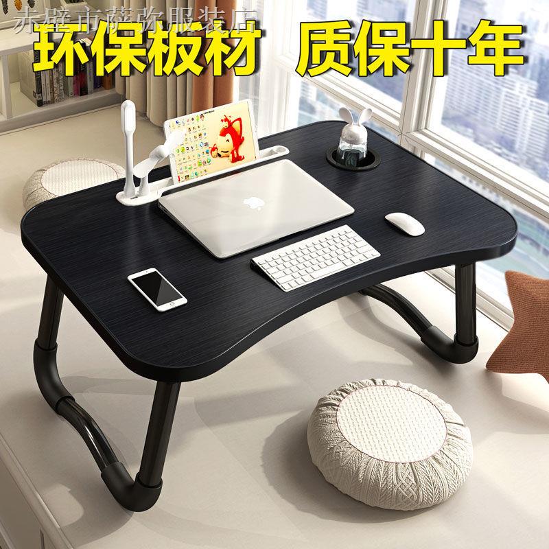 Bàn nhỏ xếp gọn ghi viết học hành để máy tính nằm giường ký túc xá sinh viên
