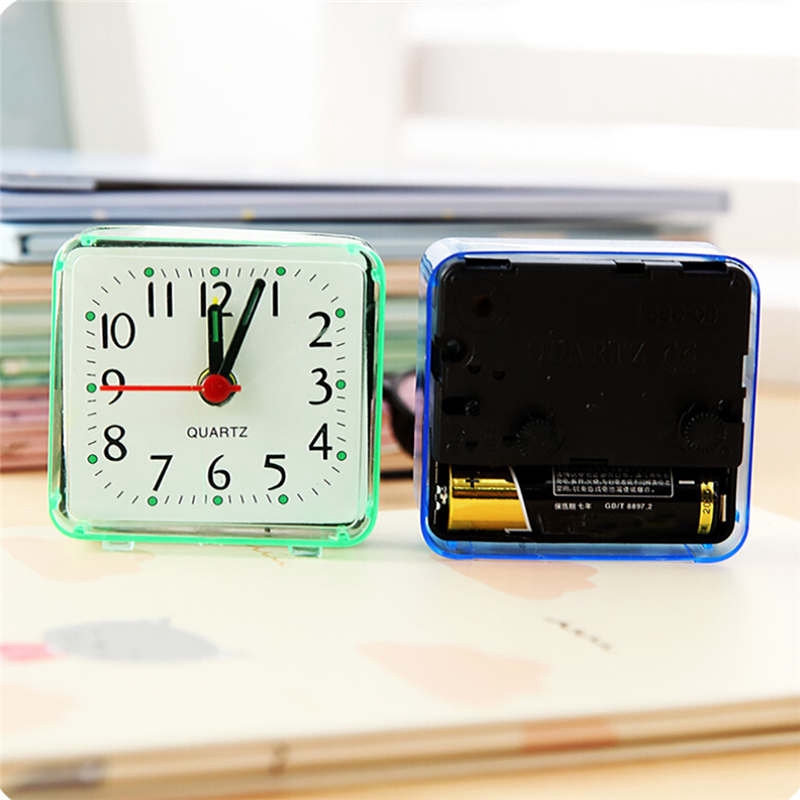 Đồng hồ báo thức hình vuông chạy bằng pin có đèn và nhạc để bên cạnh giường bé