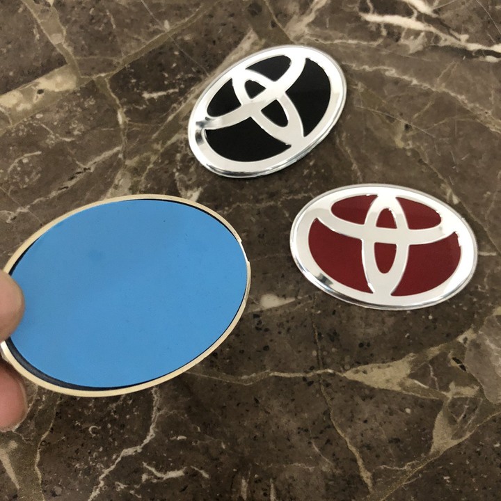 Logo biểu tượng vô lăng xe ô tô Toyota. Kích thước 68x48mm - Có 3 màu: Đen, Đỏ, Xanh