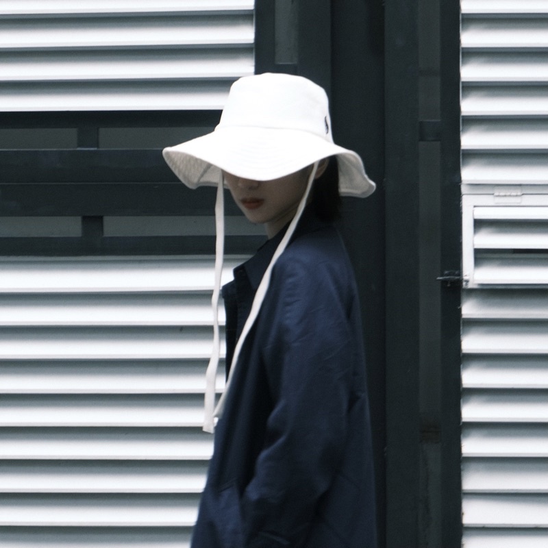 Mũ rộng vành màu trắng, có thể tháo rời dây nón, đội được 2 kiểu NEE NEE STRAP BUCKET HAT