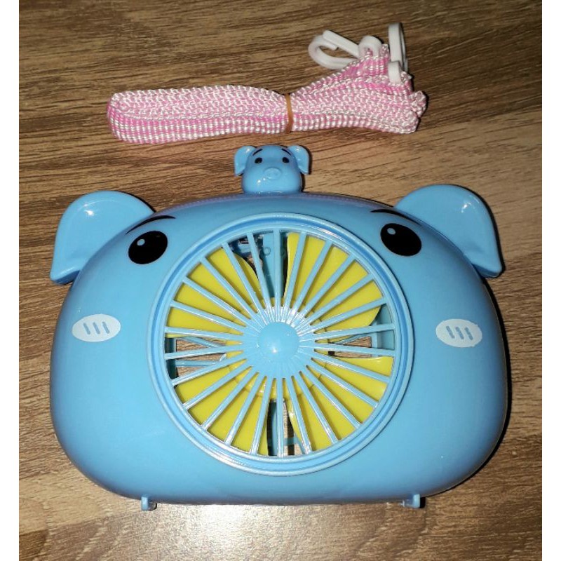 Một chiếc quạt để bàn mini bằng nhựa có dây đeo tặng kèm pin