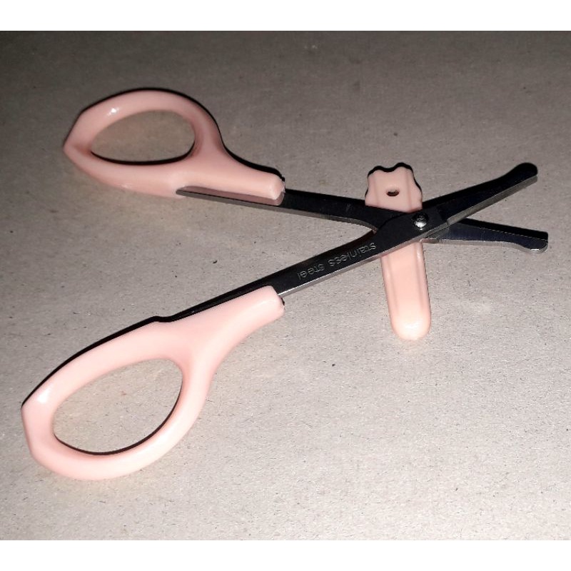 Một chiếc kéo mini dài 9 cm dùng cắt lông mi hoặc lông mũi bằng thép không gỉ có đầu bầu an toàn