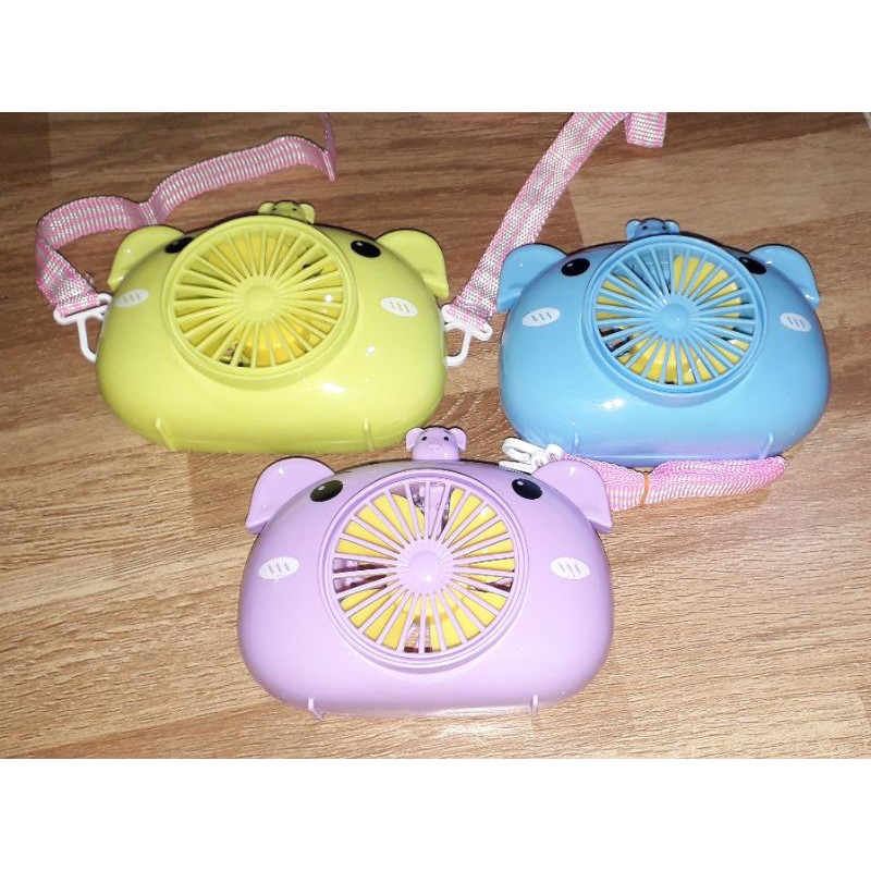 Một chiếc quạt để bàn mini bằng nhựa có dây đeo tặng kèm pin