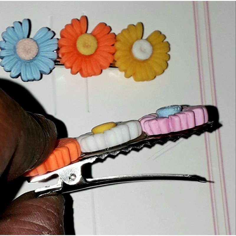 Một chiếc kẹp tóc bằng inox có 3 bông hoa bằng nhựa rất đẹp