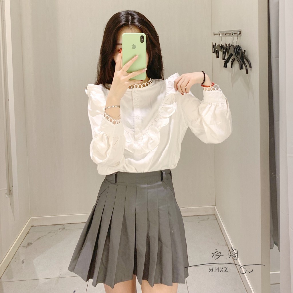 Áo sơ mi trắng cổ bèo dài tay bồng phối viền ren.