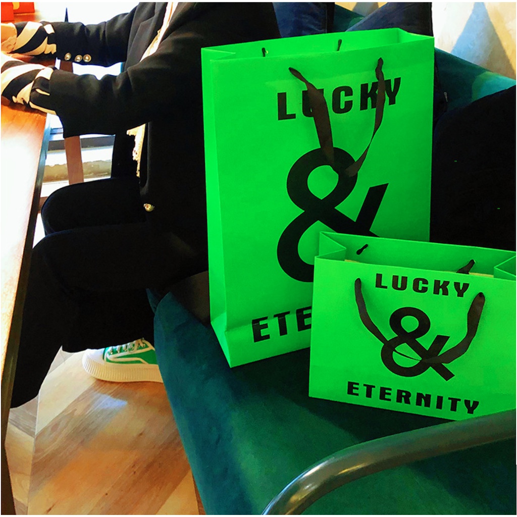 Túi giấy bìa cứng xanh logo đen "LUCKY & ETERNITY", quai vải mềm