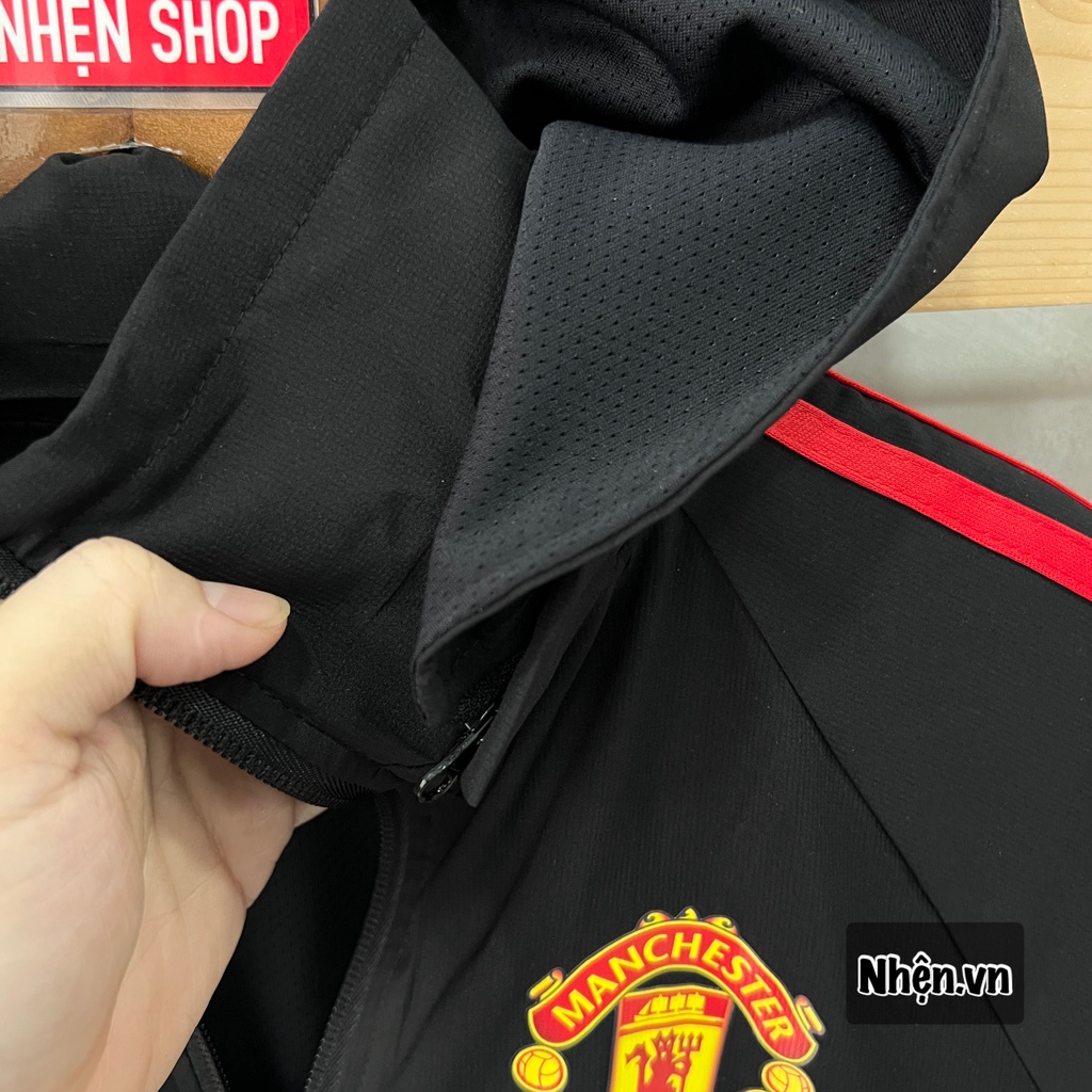 Áo khoác gió MU đen sọc đỏ mùa giải 2022/23 vải gió trượt nước, chống nắng