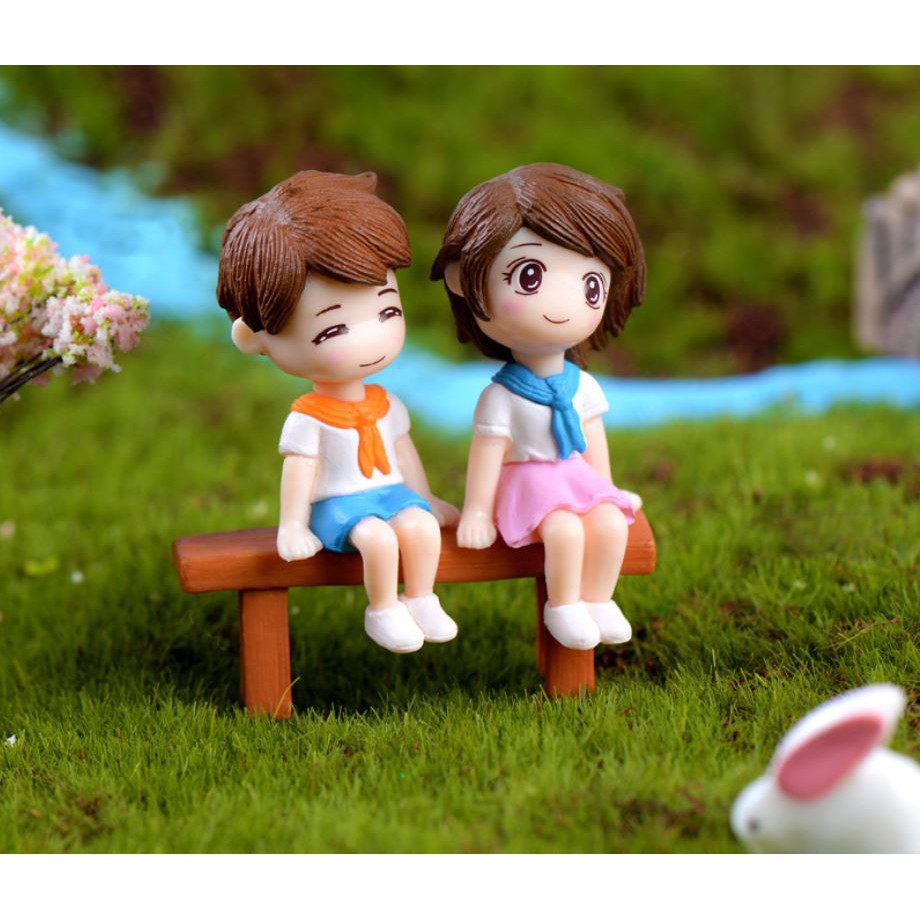 Cặp đôi đứng ngồi trên bãi cỏ trên ghế bé trai gái - mô hình trang trí tiểu cảnh