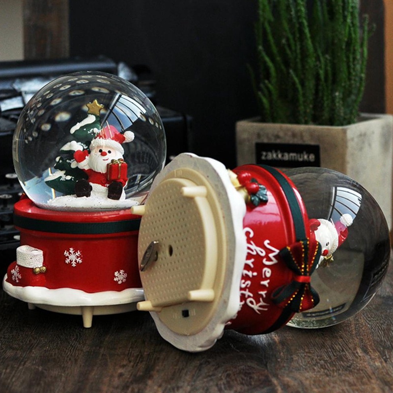 Hộp nhạc có hàng chữ "Merry Christmas" và quả cầu pha lê chứa ông già Noel