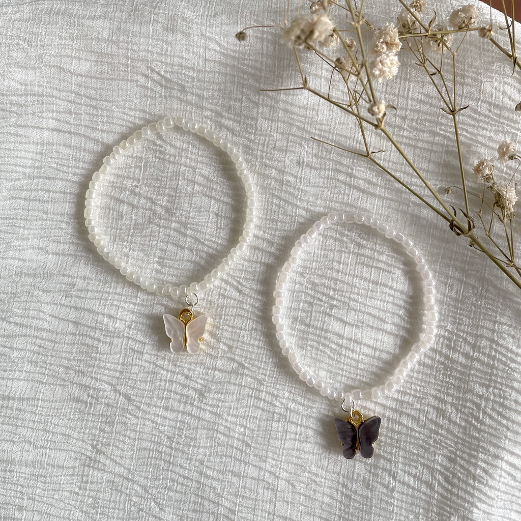 Vòng tay handmade mix màu trắng đục và charm bướm