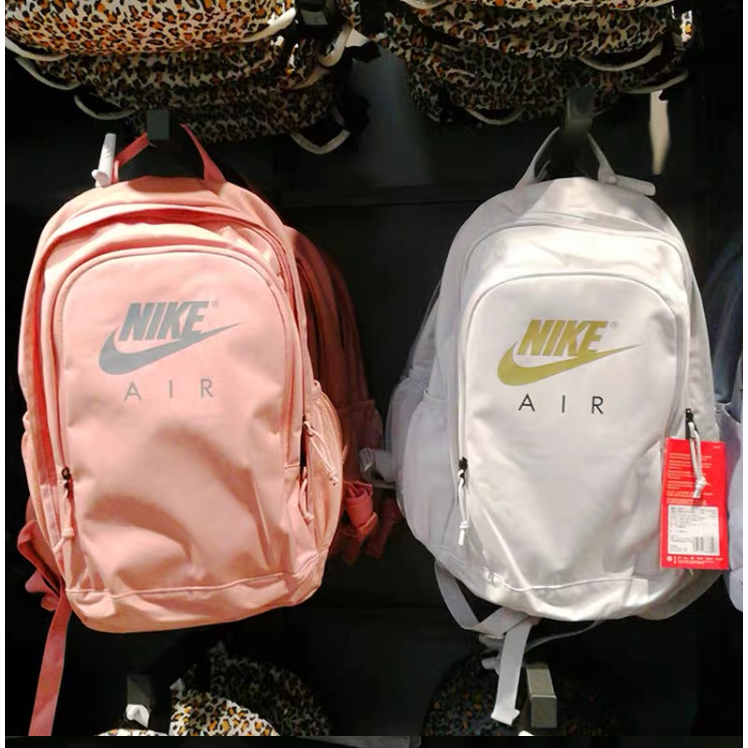 The plain color backpack features a unique Nike logo motif