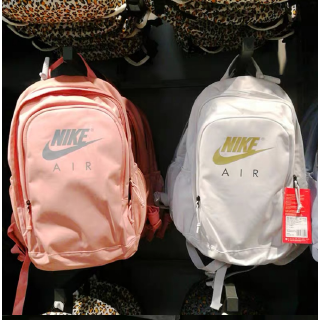 The plain color backpack features a unique Nike logo motif
