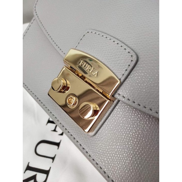 Túi đeo chéo nữ FURLA METROPOLIS  chi tiết chuẩn, từ đường keo mũi chỉ đến logo khắc đều sắc nét. Size 21cm