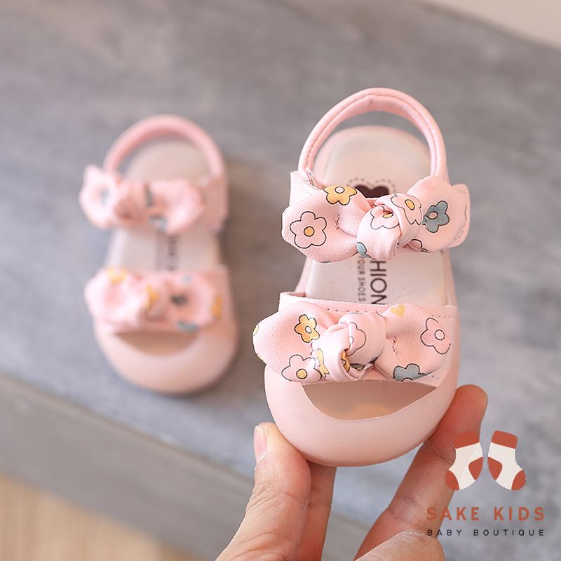 Sandal tập đi chống vấp phối nơ hình Bông hoa mũi có đế chống trơn trượt kiểu dáng Hàn Quốc mới nhất M865