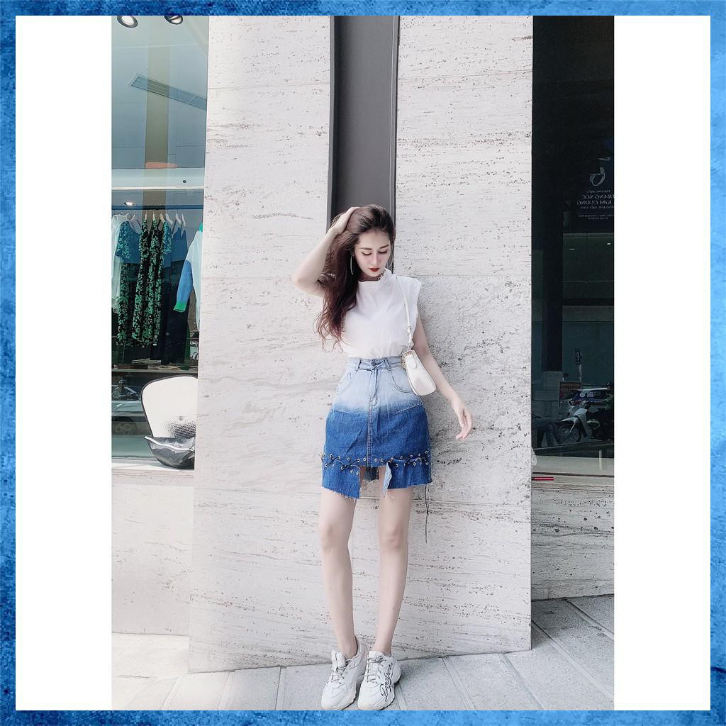 Chân váy denim ngắn, cạp cao loang màu túi chéo, gấu đan dây. Mã V9135