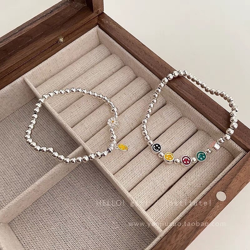 Vòng tay dây cước charm mặt cười-hoa cúc