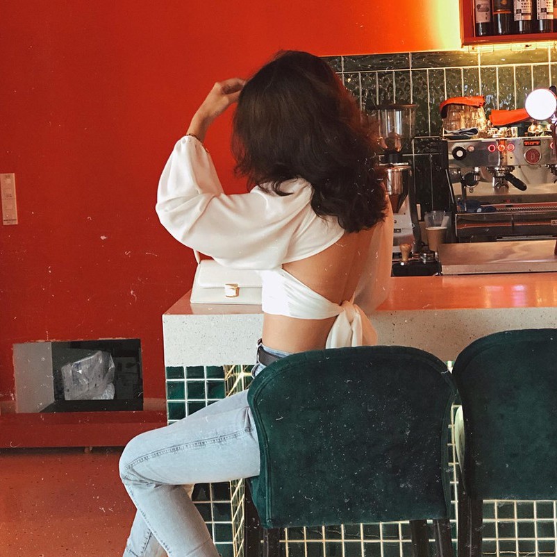 Áo croptop cổ V, tay dài thắt nơ sau lưng, có đính kèm mút ngực