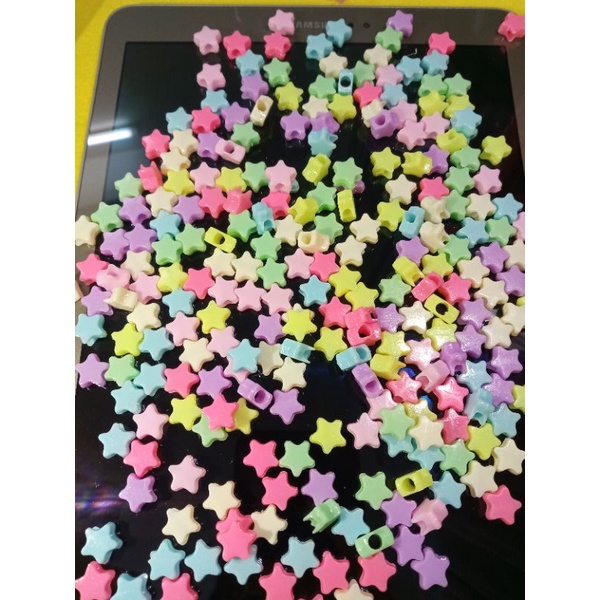 gói 100 hạt nhựa hình ngôi sao đủ màu và 2 mét cước thun dùng để xõ chuỗi đeo tay, hạt có thể làm cài tóc
