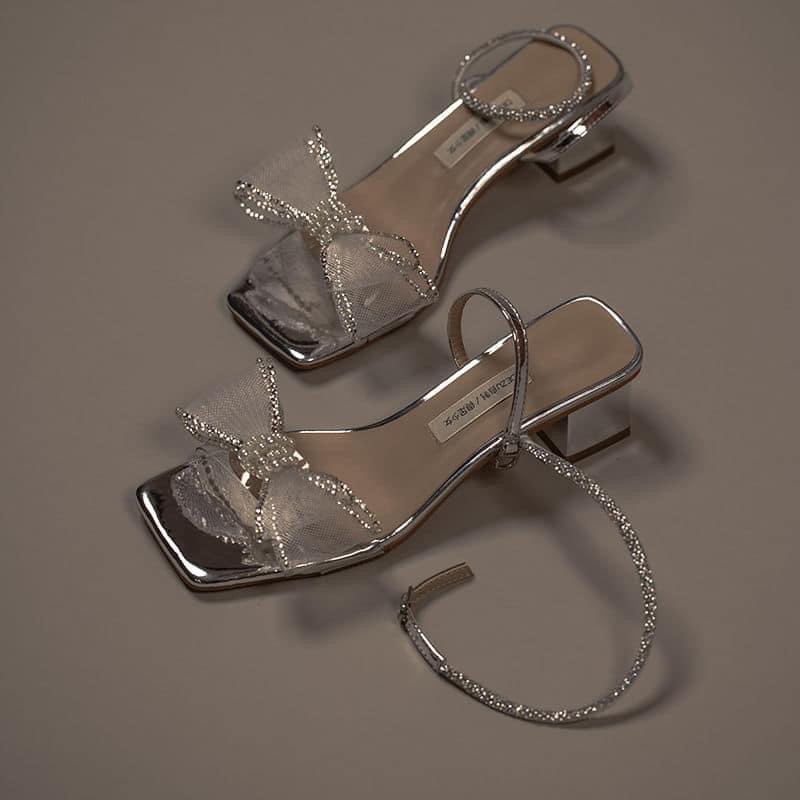 Sandal phối hoa nơ trắng bóng với thiết kế đầu mũi vuông phong cách tiểu thư