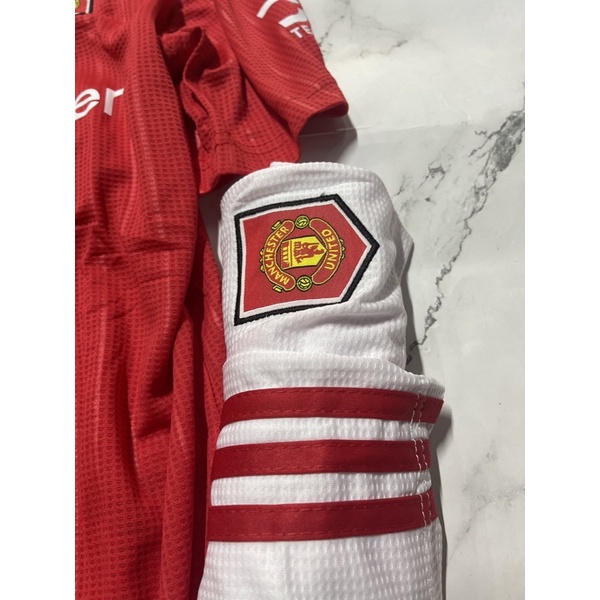 Set bộ quần áo thể thao nam nữ bóng đá clb mu manchester united áo đỏ quần trắng vải gai thái logo thêu đầy đủ