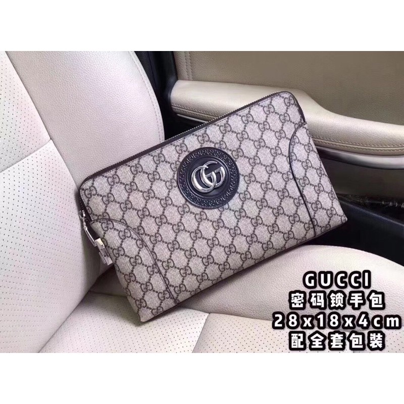 ví tab đứng cầm tay da in hoạ tiết huy hiệu đính chữ G đôi mặt trước gucci Gc gG