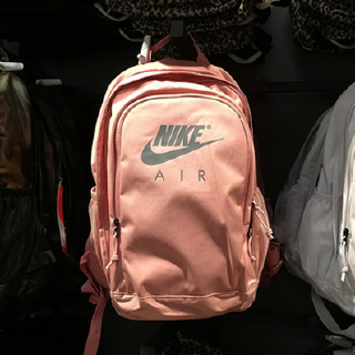 The plain color backpack features a unique Nike logo motif