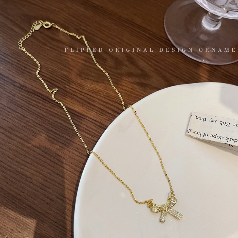 Vòng cổ dây xích gắn nơ vàng dính đá zircon sang trọng