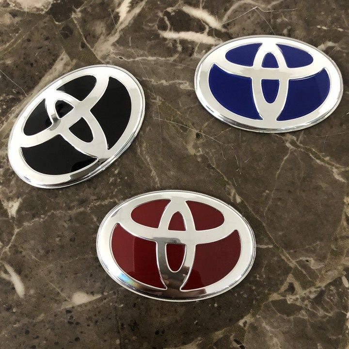 Logo biểu tượng vô lăng xe ô tô Toyota. Kích thước 68x48mm - Có 3 màu: Đen, Đỏ, Xanh