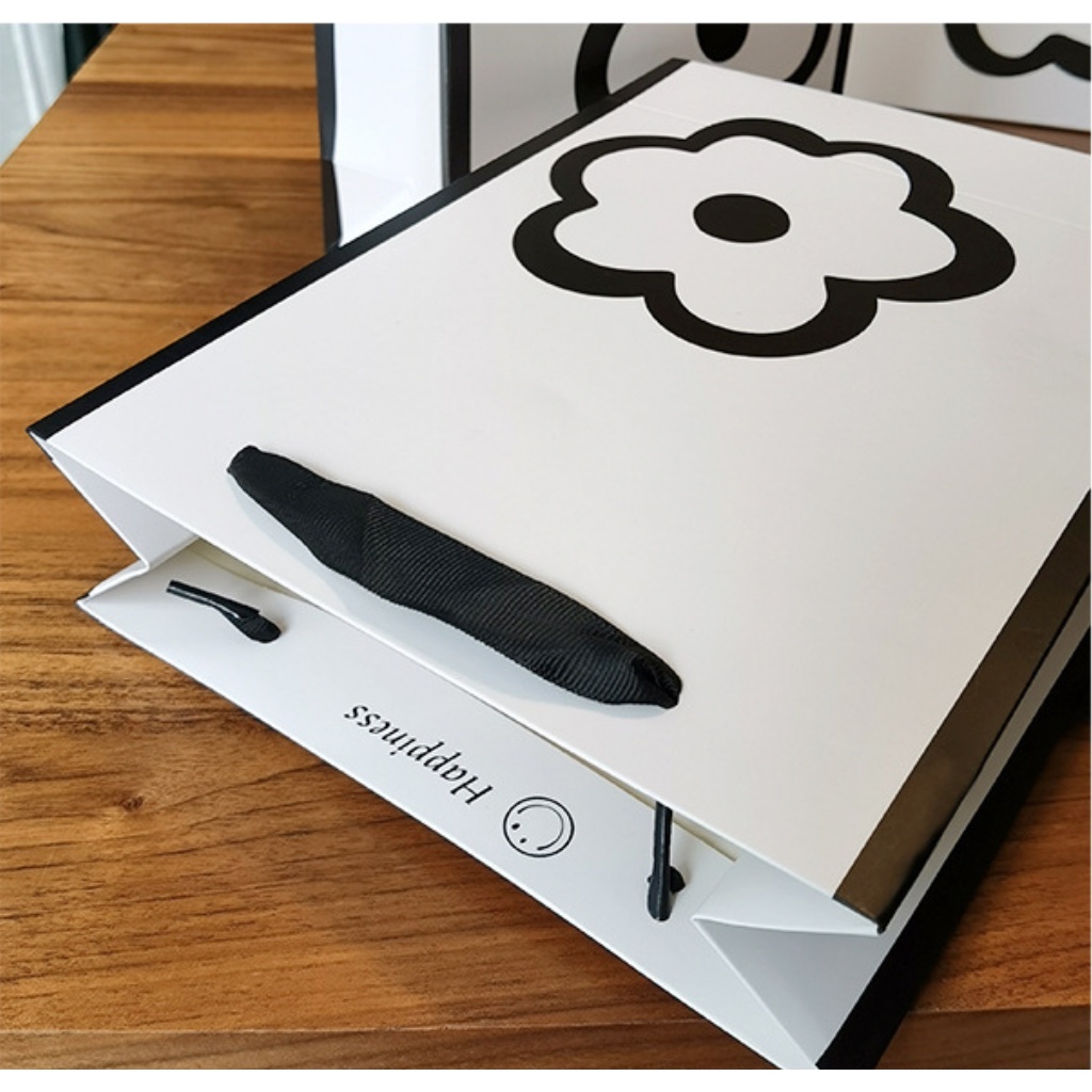 Túi giấy bìa cứng màu trắng kết hợp logo hình HOA, quai xách vải đen mềm