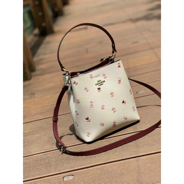 Túi đeo vai Co@ch bucket hoạ tiết kèm dây đeo chéo