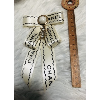 Cài áo nơ phối logo. KT 9x16cm