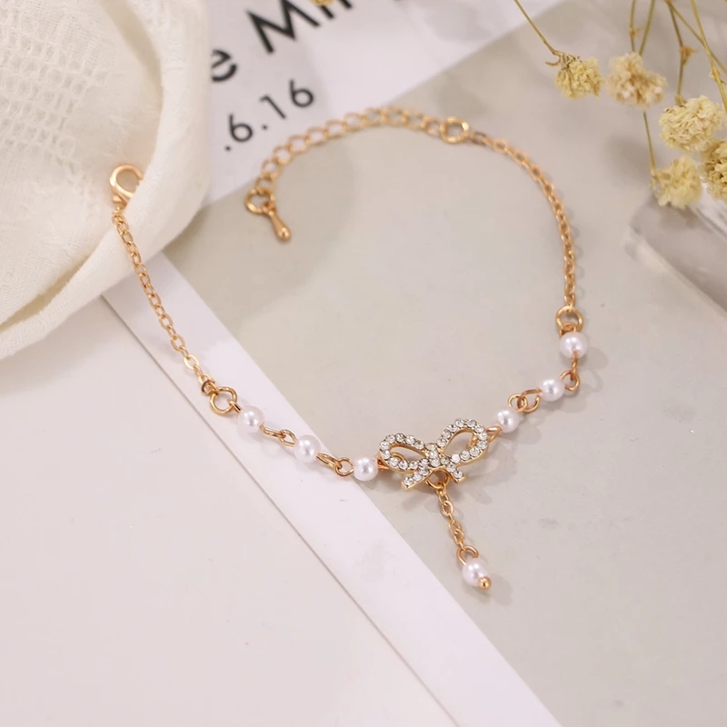 Lắc tay mặt nơ đính pha lê giả và xỏ hạt ngọc trai nhân tạo thời thượng cho quý cô thanh lịch