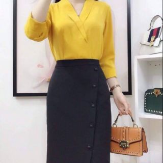Chân váy bút chì xẻ tà lệch phối cúc.