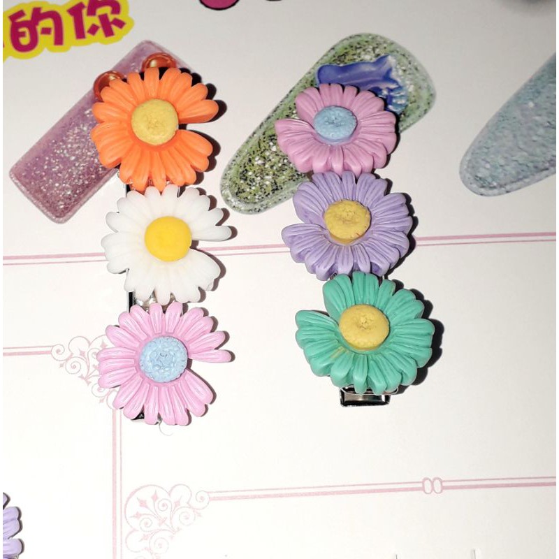 Một chiếc kẹp tóc bằng inox có 3 bông hoa bằng nhựa rất đẹp