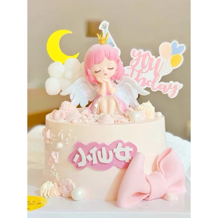 Trang trí cô gái thiên thần có cánh váy hồng ngồi