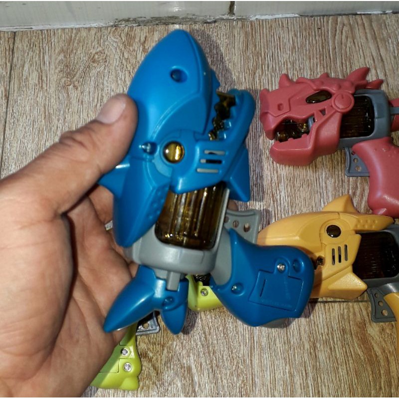 Một cái mô hình khủng long hoặc cá mập bằng nhựa có nhạc và đèn led rất đẹp có sẵn pin