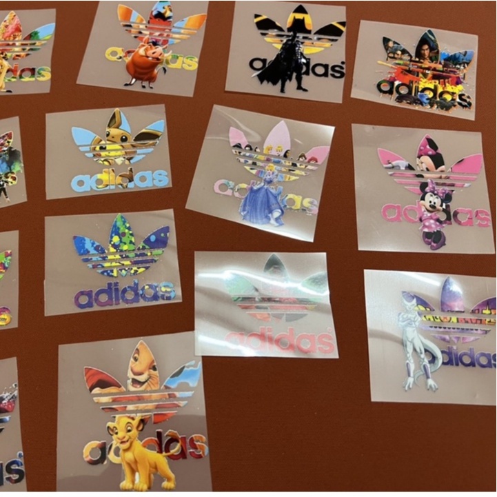 - Logo Adidas nhiều màu in trực tiếp lên vải bằng bàn ủi, bàn là