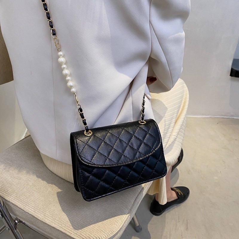 Túi xách nữ đeo chéo kẹp nách da thêu có nắp dây xích phối hạt ngọc nhân tạo.