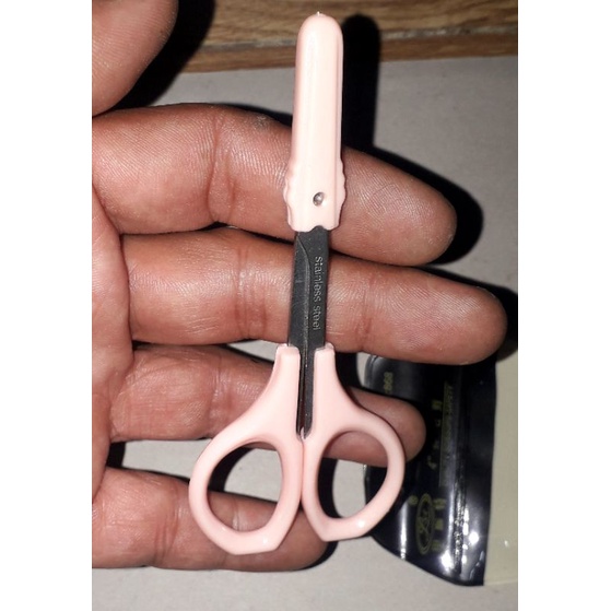 Một chiếc kéo mini dài 9 cm dùng cắt lông mi hoặc lông mũi bằng thép không gỉ có đầu bầu an toàn