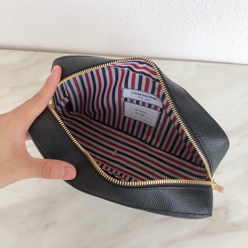 Túi clutch mới làm bằng da bò vân bóng. Thương hiệu này luôn giữ được sự chú trọng và hấp dẫn thom browne