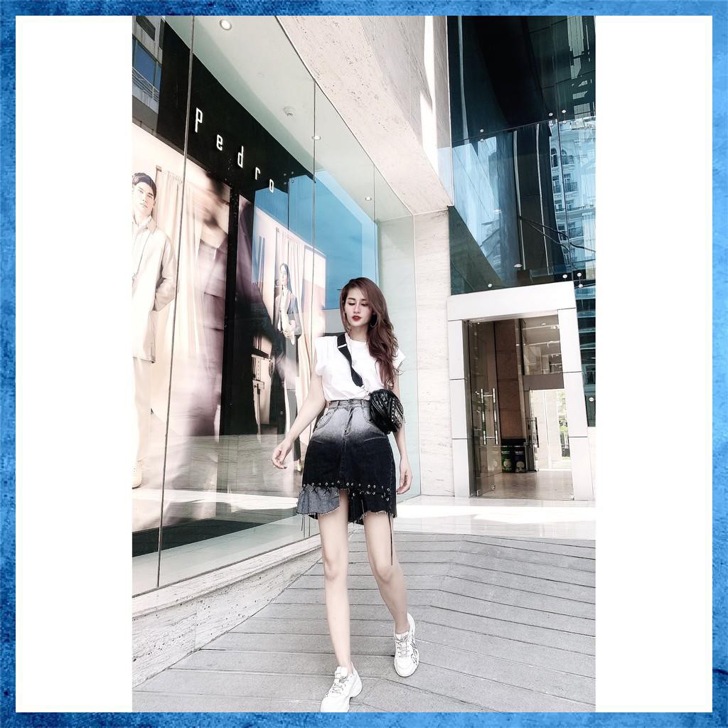 Chân váy denim ngắn, cạp cao loang màu túi chéo, gấu đan dây. Mã V9135