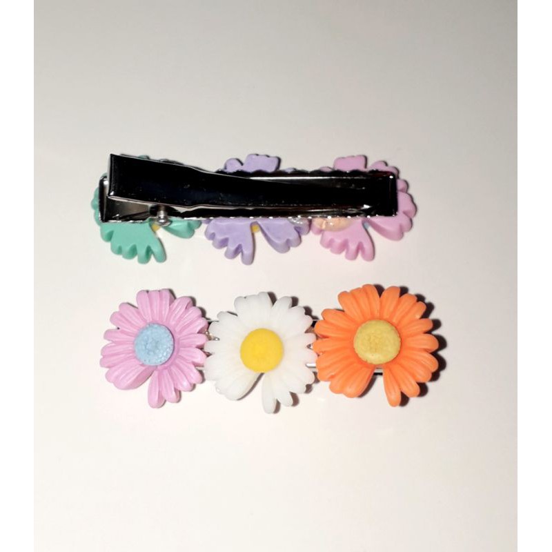 Một chiếc kẹp tóc bằng inox có 3 bông hoa bằng nhựa rất đẹp