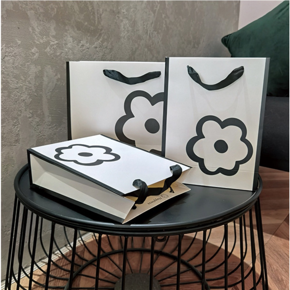 Túi giấy bìa cứng màu trắng kết hợp logo hình HOA, quai xách vải đen mềm