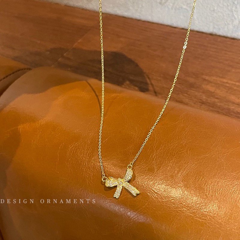 Vòng cổ dây xích gắn nơ vàng dính đá zircon sang trọng