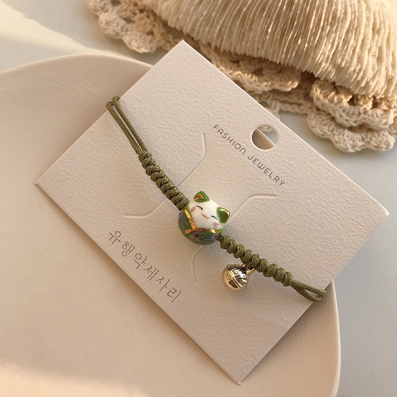 Vòng đeo tay, lắc tay nữ hình chú mèo Makeni Neko mang lại may mắn cho thân chủ.  Vòng tay dây bện mặt mèo xinh xắn.