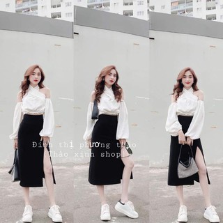 áo sơ mi trắng xoắn trễ vai, chân váy đen xẻ tà sang chảnh