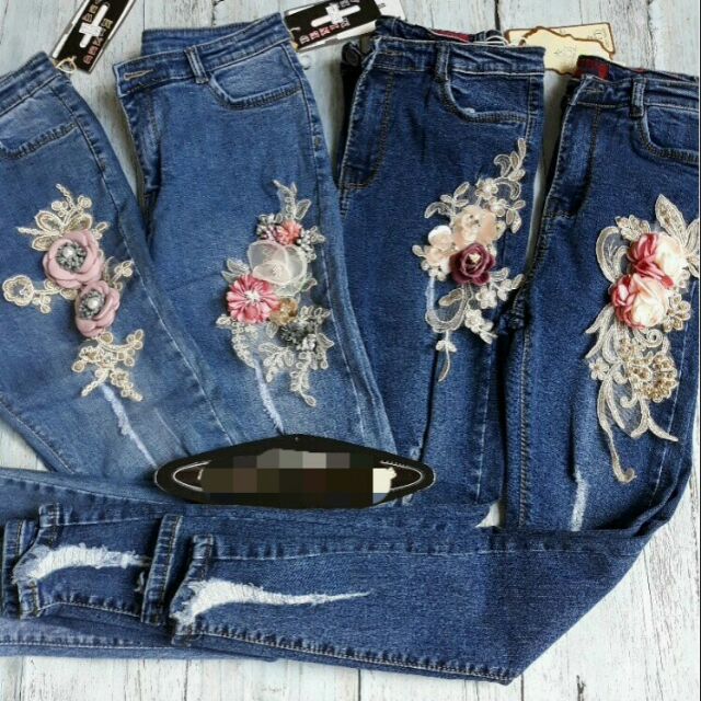 Quần jeans đính hoa nổi.