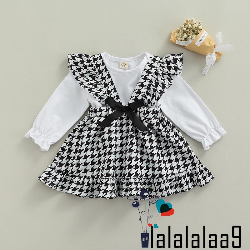 Set đồ 2 món gồm áo liền quần cổ tròn tay dài màu trắng + váy yếm họa tiết răng cưa dành cho bé gái