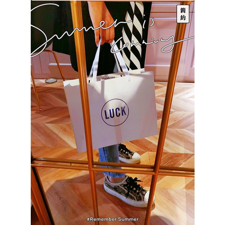 Túi giấy bìa cứng trắng logo "I DO" và "LUCK" màu xanh, quai vải mềm