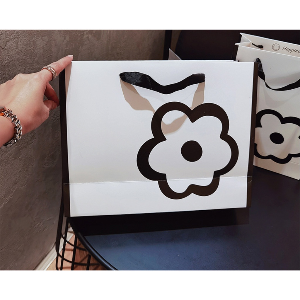 Túi giấy bìa cứng màu trắng kết hợp logo hình HOA, quai xách vải đen mềm